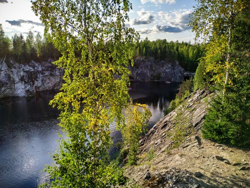 Free Beautiful landscape of a serene lake in Republic of Karelia, Russia, with lush trees and rocky cliffs. Stock Photo