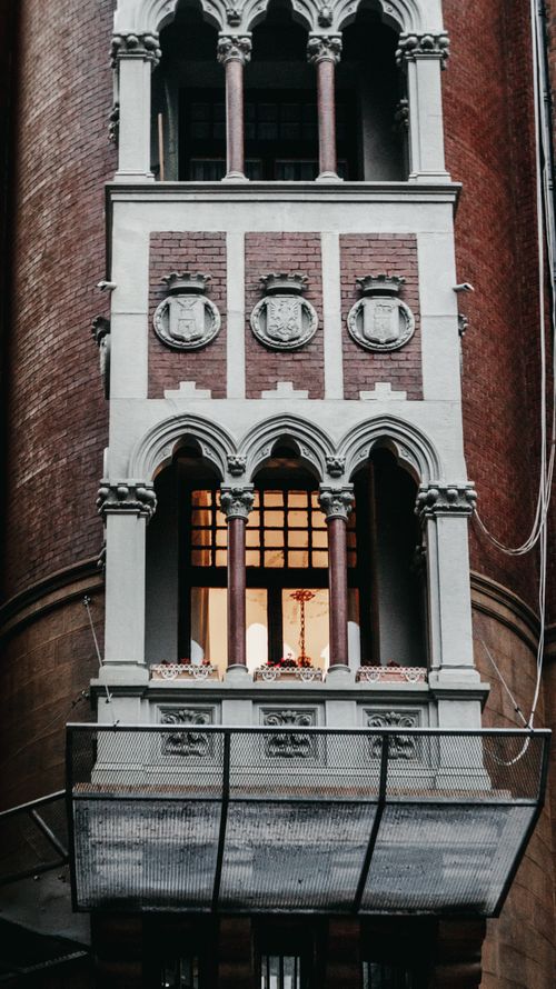 Free Close-up of a detailed Gothic building facade with arched windows and decorative elements. Stock Photo