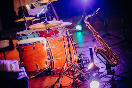 Close-up of drums and saxophone on stage with bright lights, perfect for a concert theme.
