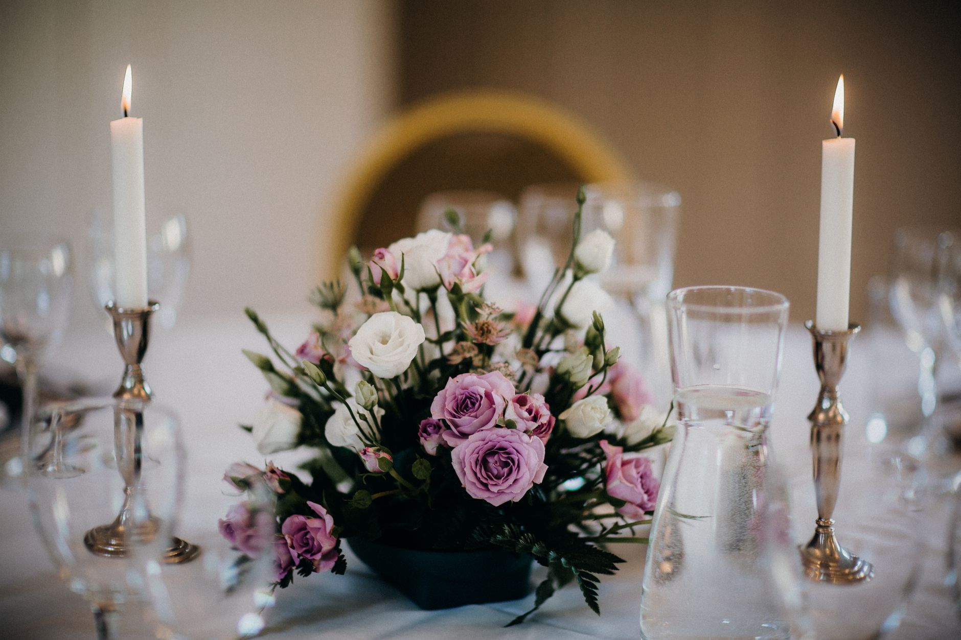 Beautiful floral centerpiece with candles on a wedding table.