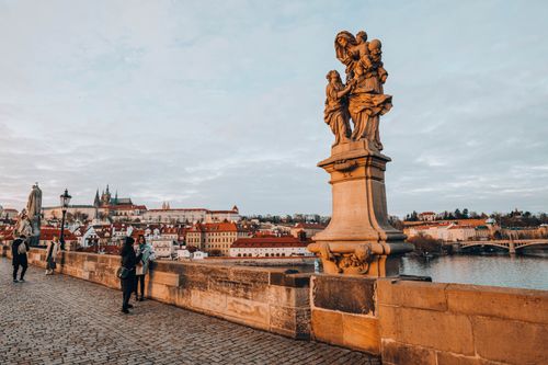 Free Explore the iconic Charles Bridge with its historic statues against Prague's enchanting skyline at dusk. Stock Photo