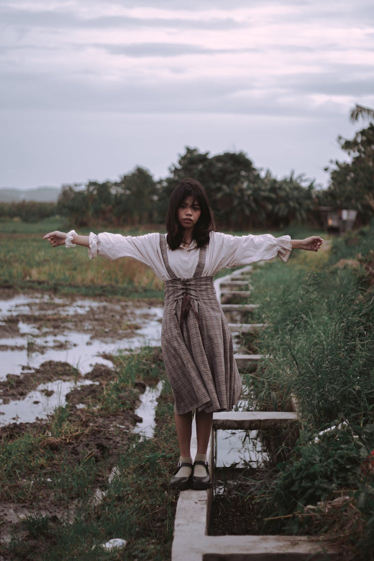 A Woman Standing Near The Drainage