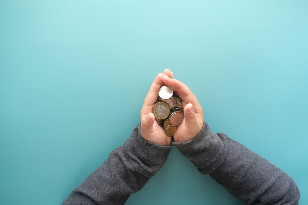 Hands holding coins for donation