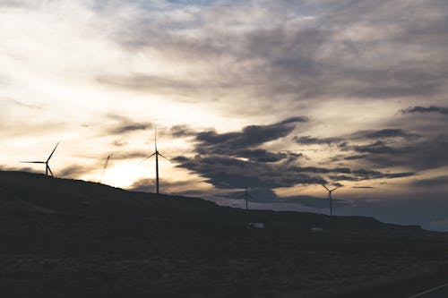 Free Wind Turbines on Hill Under Cloudy Sky Stock Photo