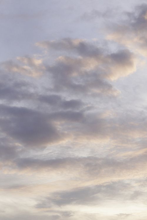 Free A tranquil view of soft white clouds against a light pastel sky during sunrise. Stock Photo