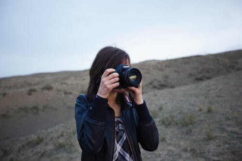 DSLR 카메라, 검은색 가죽 자켓, 렌즈의 무료 스톡 사진