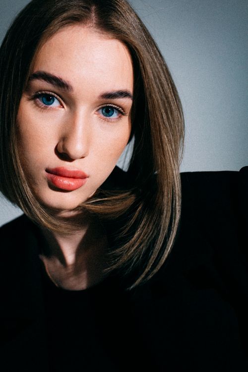 Free Portrait of a woman with blue eyes and elegant makeup, captured in a studio setting. Stock Photo