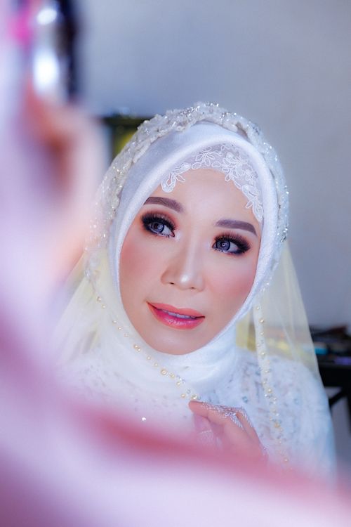 Free Beautiful bride wearing a traditional white hijab and glamorous makeup, showcasing elegance and style. Stock Photo