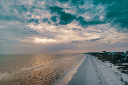Wide Angle Photo of Shore Under Cloudy Sky