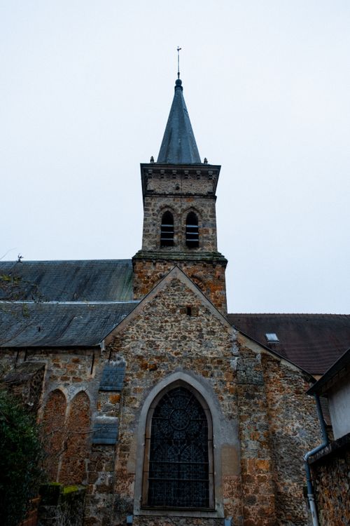 Free Historic stone church facade with gothic arches and windows, captured in daylight. Stock Photo