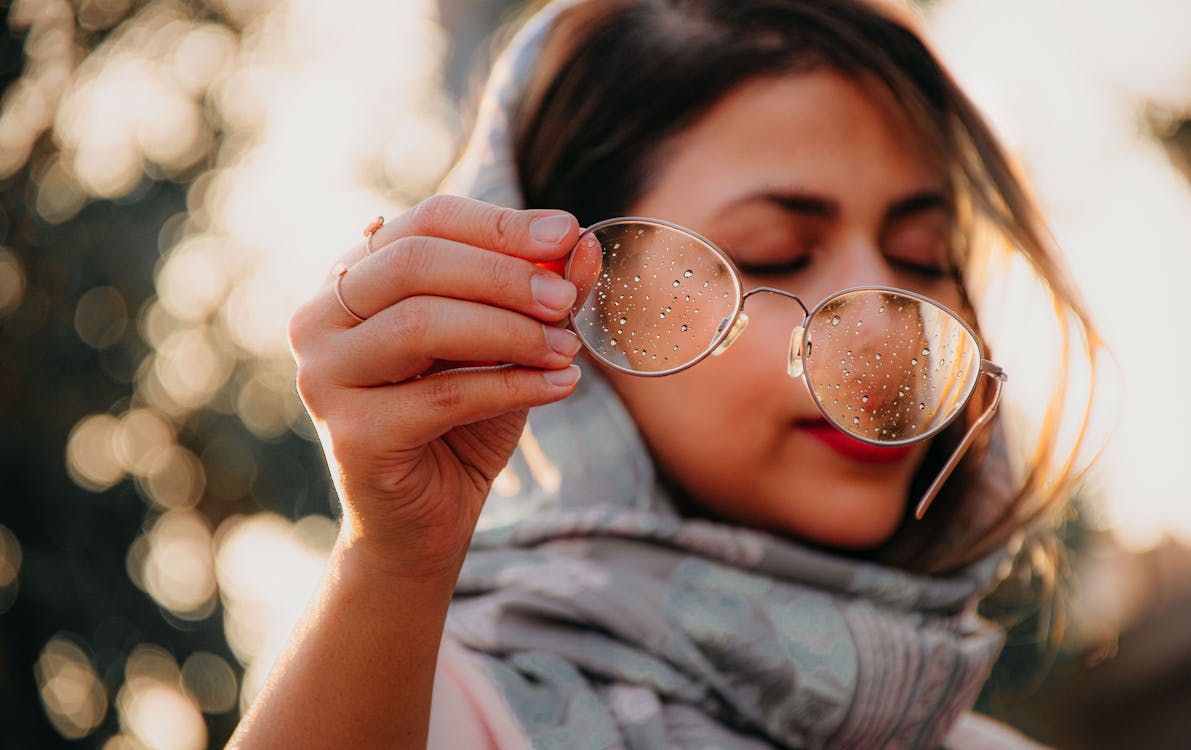 Close Up Photo of Woman Holding Eyeglasses