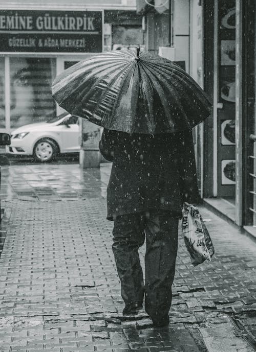 Grayscale Photo of Person Holding Umbrella