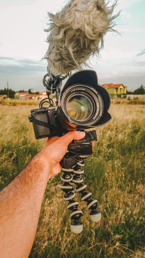 Man Holding a Camera and a Microphone 