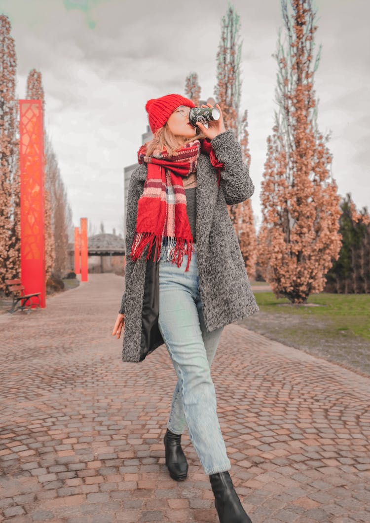 Woman In Coat Drinking In Park