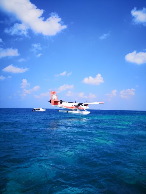 Free A vibrant seaplane and a boat against the clear blue waters and sky of the Maldives. Stock Photo