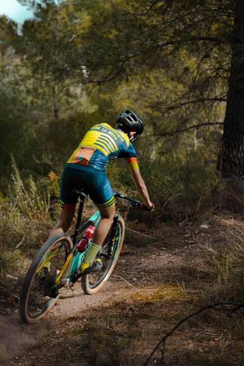 A Man in Yellow Shirt Riding on Bicycle