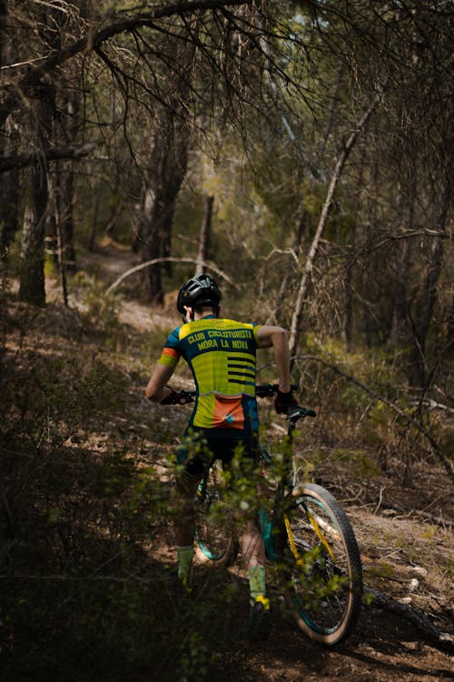 A Man with a Bicycle in a Forest 