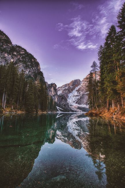 Breathtaking mountain landscape with serene lake reflection during dawn, showcasing nature's tranquility.
