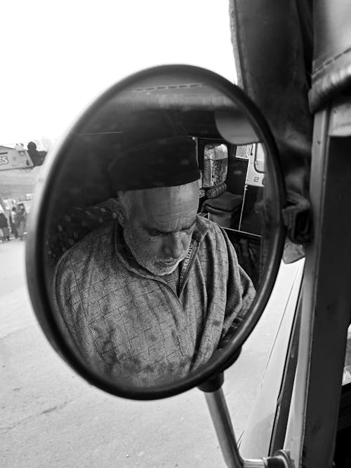 Grayscale Photo of a Man's Reflection in the Side Mirror