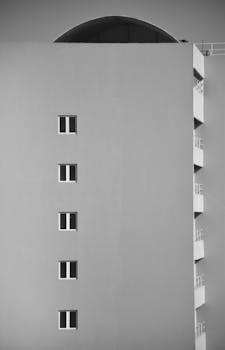 A striking minimalist black and white photo of a modern building facade with geometric lines.