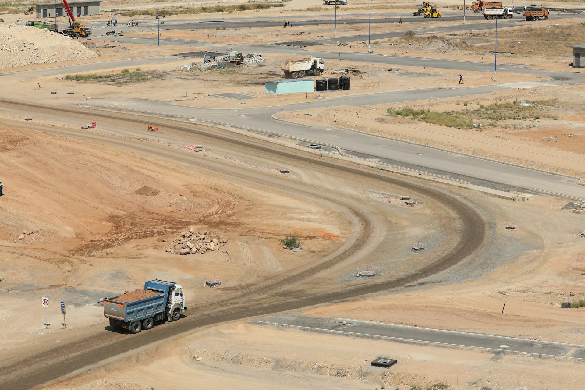 Drone shot of a developing construction site in Konza, Machakos County with dump trucks and dirt roads.