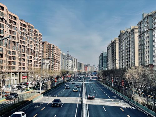 Free Aerial view of a city street flanked by high-rise buildings and heavy traffic on a clear day. Stock Photo