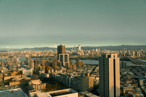 Free A panoramic view of a city's skyline with mountains in the background under a clear sky. Stock Photo