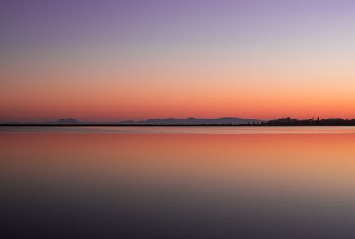 Free Peaceful sunset view over a calm sea with vibrant sky colors in Spain. Stock Photo