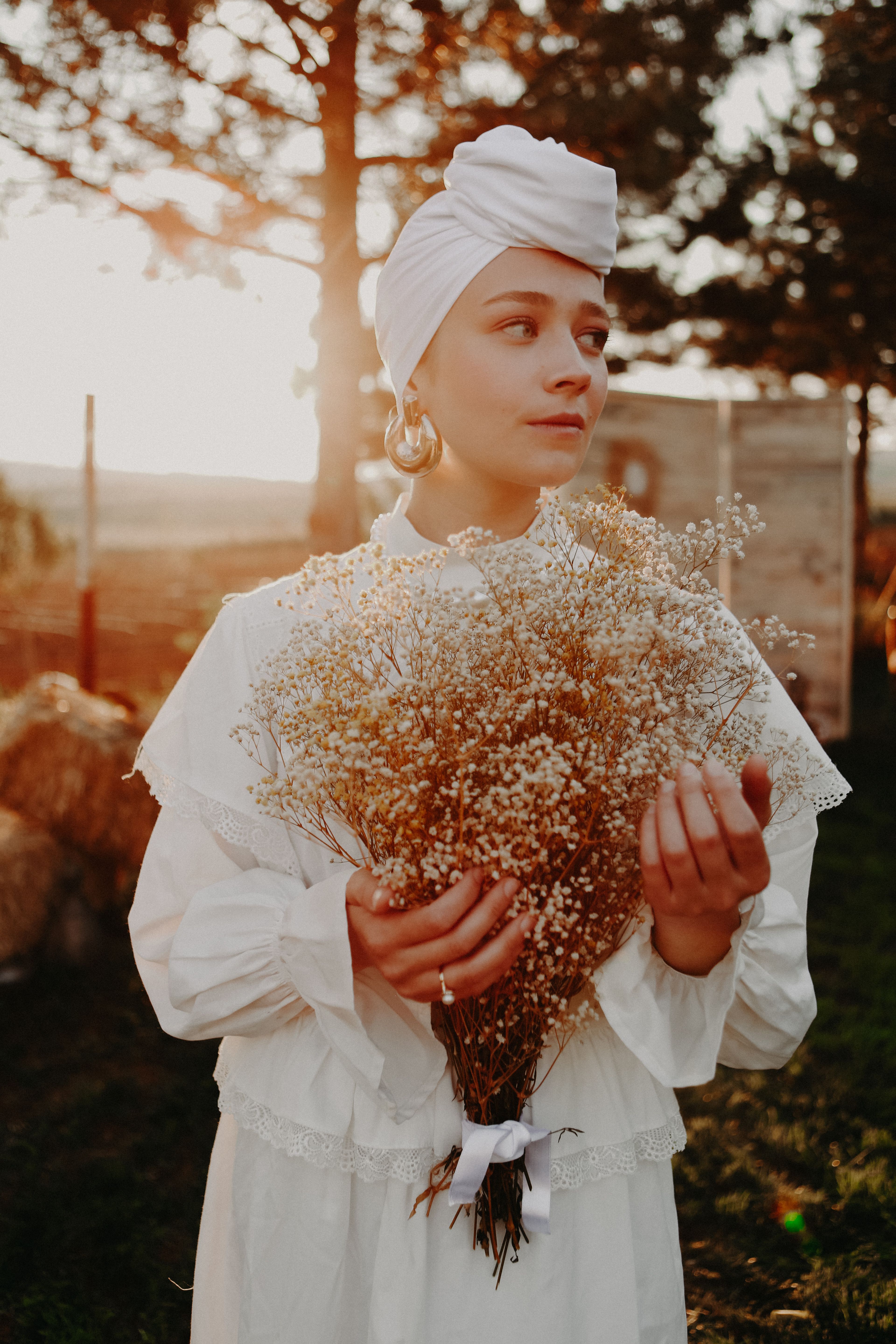 A Woman in White Dress Holding White Bouquet of Flowers · Free Stock Photo