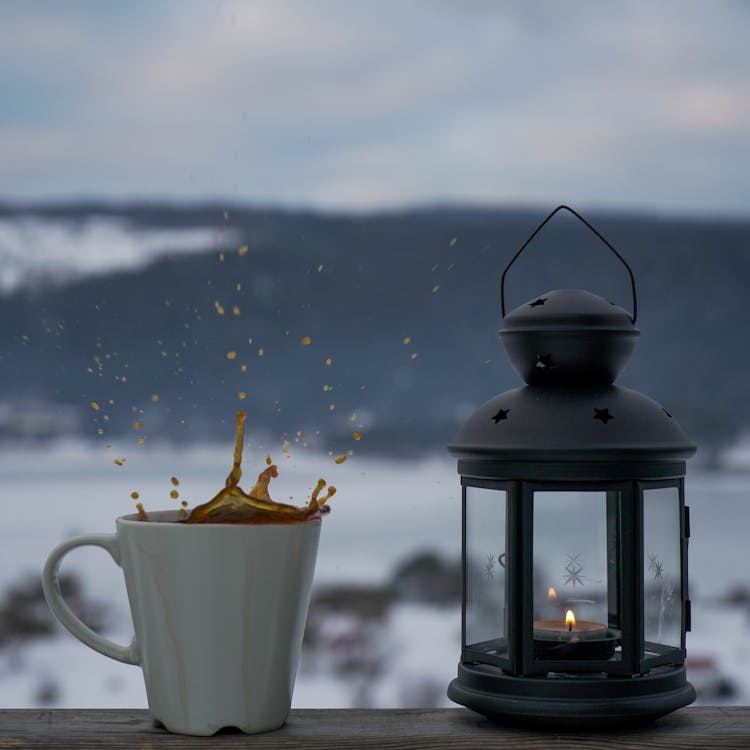 Splashing Liquid In A Cup Near A Lantern