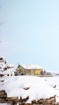 Serene winter scene with a snow-covered house in Türkiye, under a bright blue sky.