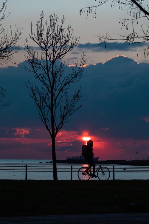 Free A breathtaking scene of a cyclist silhouetted at sunset by the Istanbul waterfront. Stock Photo