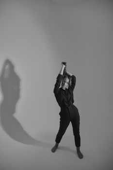 Artistic black and white portrait of a woman in a studio setting.