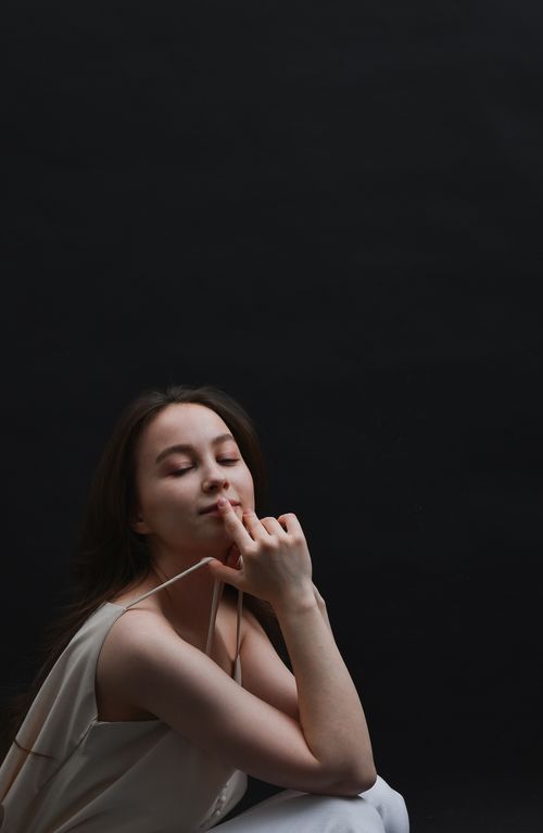 Free Elegant portrait of a young woman with closed eyes against a black background, showcasing tranquility. Stock Photo