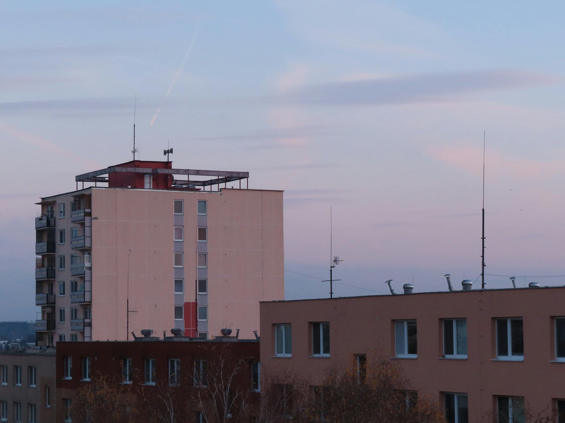 A scenic view of urban apartment buildings during sunset with a serene sky.