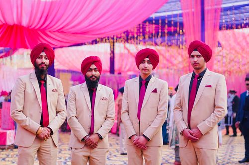 Free Four Sikh groomsmen stand in traditional attire at a vibrant wedding celebration. Stock Photo
