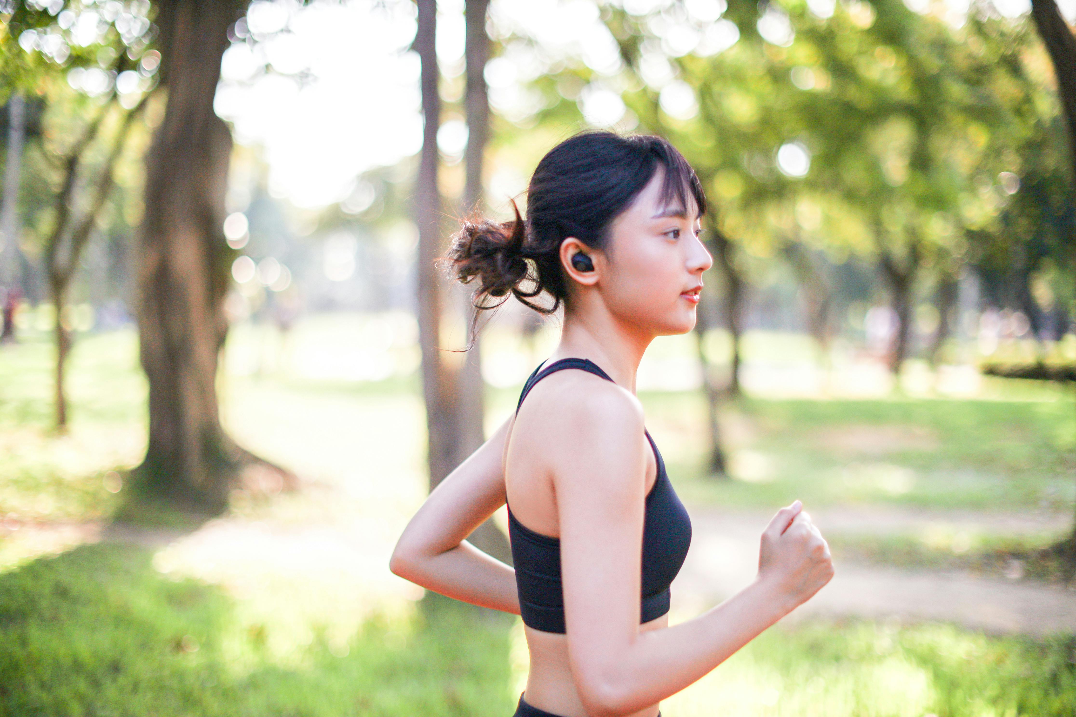 Young woman running outdoors in a city park on a cold fall - Stock Image -  Everypixel