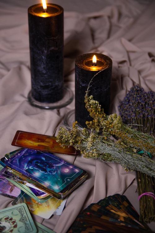 Free Intimate setting with tarot cards, candles, and herbs for mystical ambiance. Stock Photo