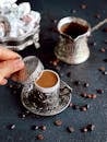 Person Holding Silver and White Ceramic Mug With Coffee