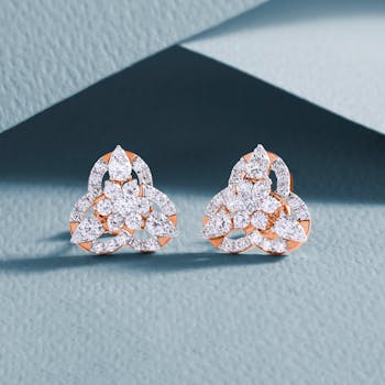 Luxurious diamond earrings with an intricate design on a textured background.