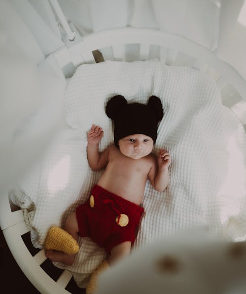 Shirtless Baby Lying on a Crib