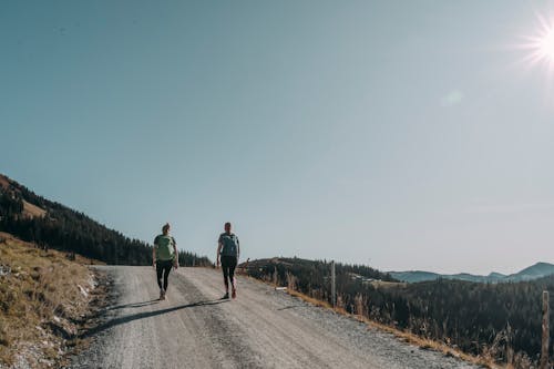 Young Women Hiking on Mountain Trail with Backpacks