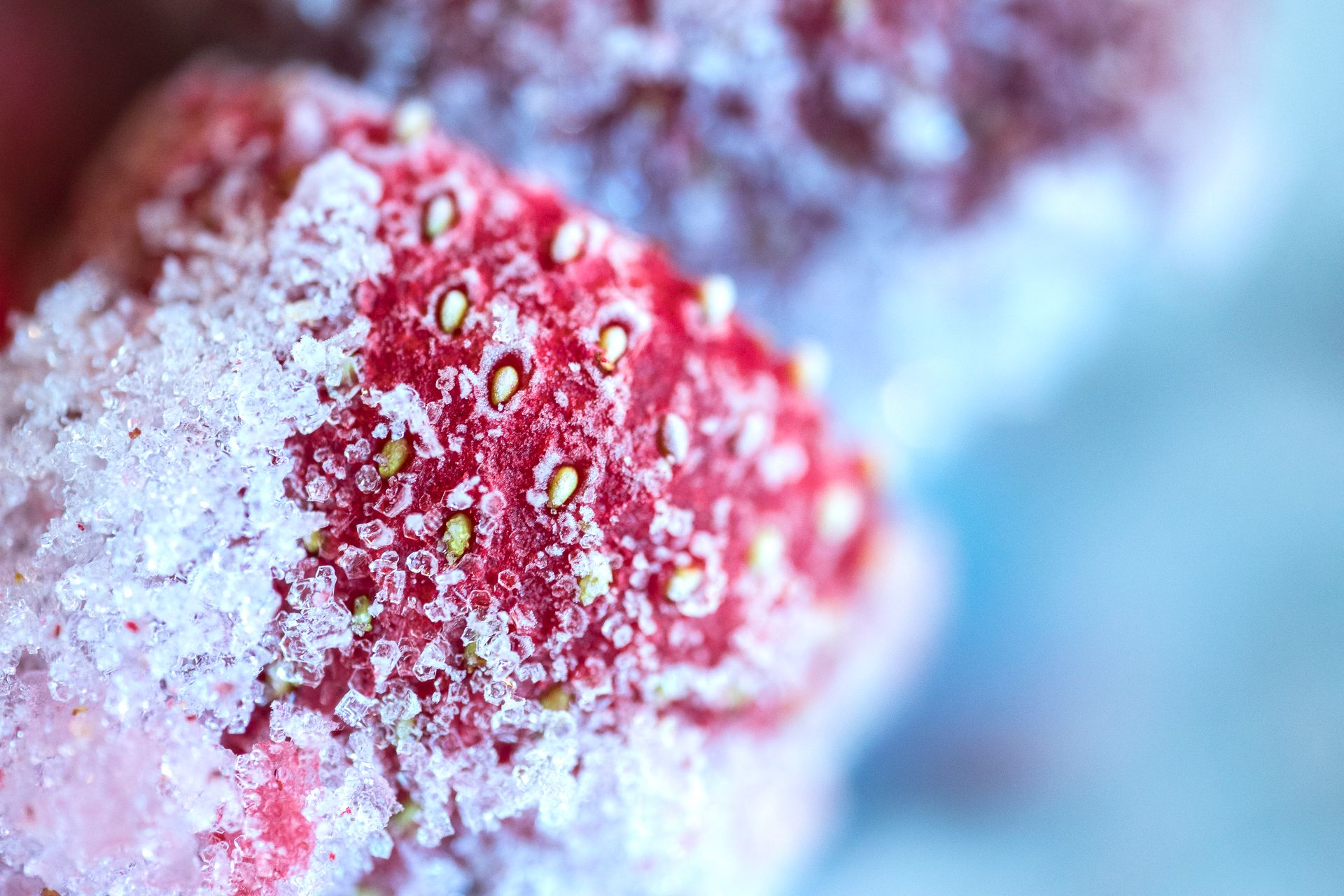 Detailed macro shot of a frozen strawberry covered in ice crystals, showcasing texture.