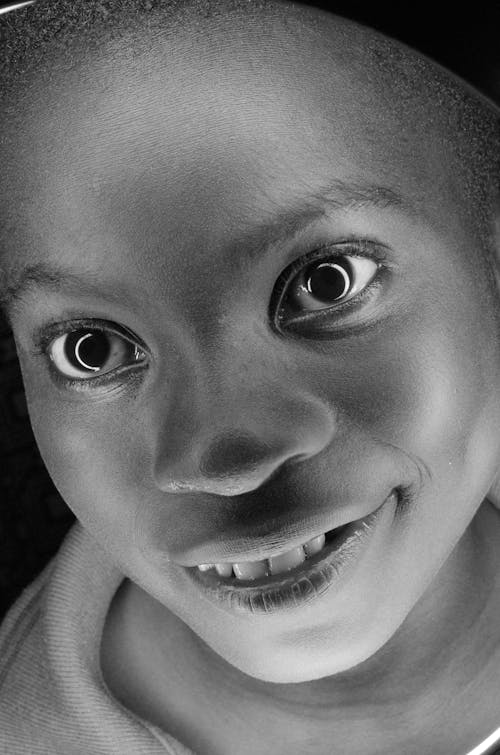 Grayscale Photo of a Smiling Child