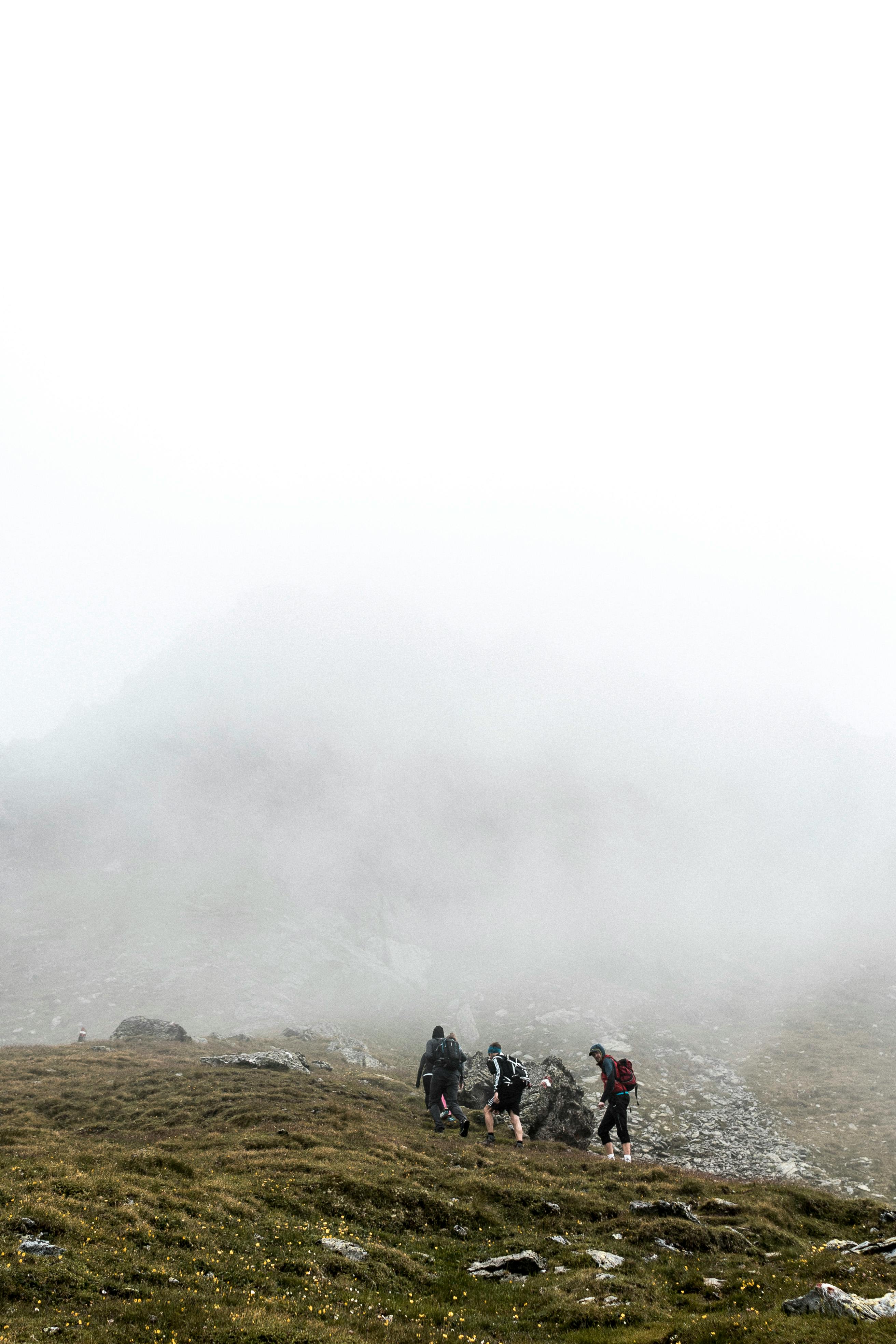Group hiking in foggy mountains of Kelchsau, Tirol, showcasing adventure and nature.