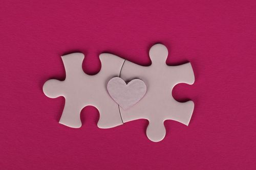 Free Two puzzle pieces with a heart shape in between, symbolizing connection and love. Stock Photo