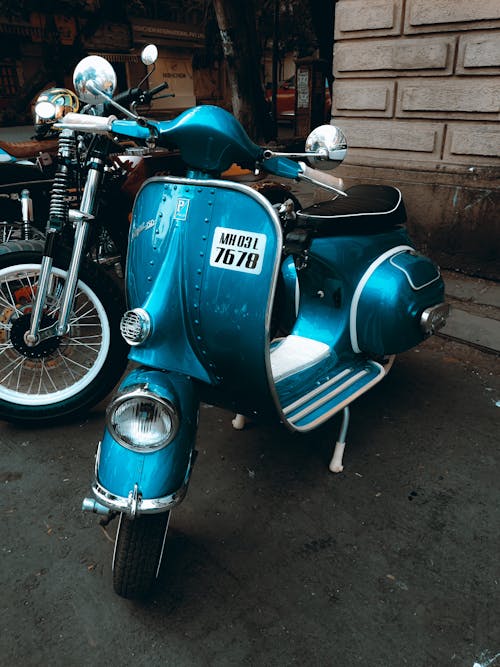 Free Blue Scooter Parked Beside a Wall Stock Photo