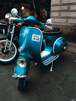 A vibrant blue vintage scooter parked on a city street, capturing retro charm and urban style.