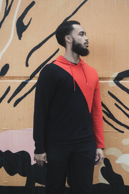 Free Man in Black and Red Long Sleeve Shirt Standing Beside Wall Stock Photo