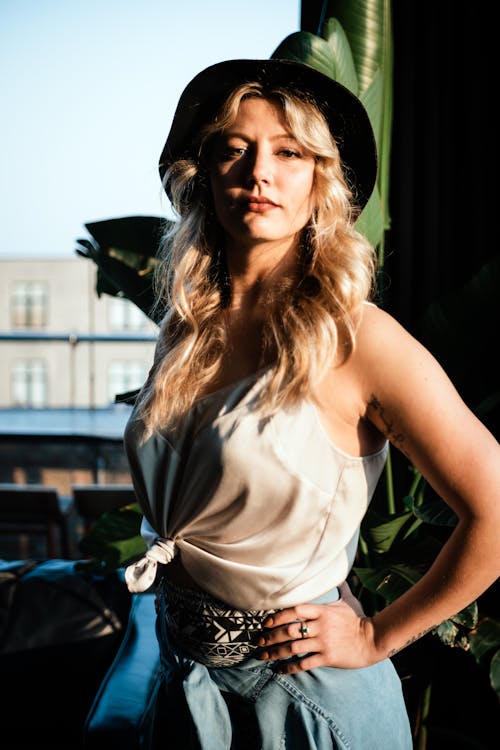 A Woman in Tank Top Wearing a Fedora Hat